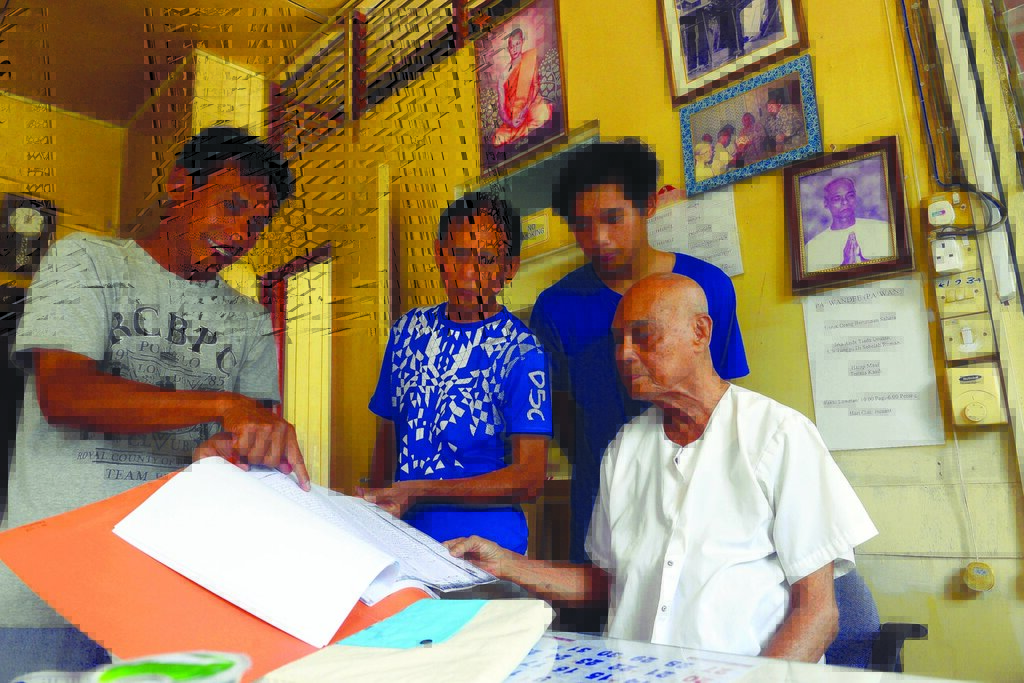 Boon Leau Aroonratana showing the agreement paper between the British government and the Siamese and Burmese community which states that the land belongs to Burmese Thai Trust 